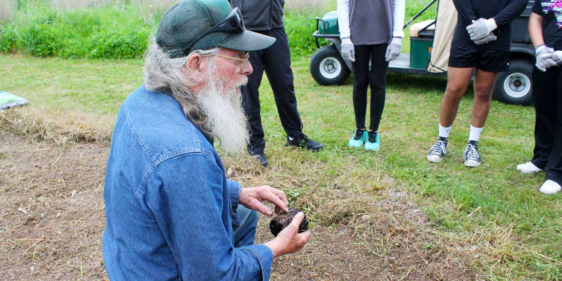 A landscaper addresses a semi-circle of students.