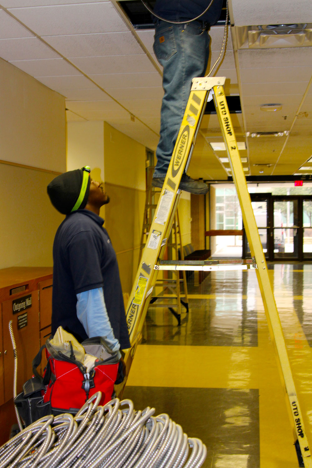 Electrical. A pair of electricians working on ceiling wiring.